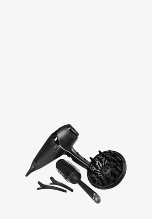 Sèche-cheveux noir avec embout diffuseur, brosse à cheveux ronde ventilée et deux pinces à cheveux noires disposées sur un fond blanc.