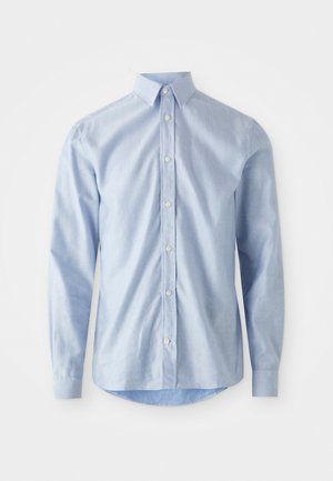 Camisa de botones azul claro hecha de algodón. Cuenta con un cuello clásico, mangas largas y un dobladillo redondeado con una textura sutil. Los botones son blancos.