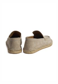 Beige suède espadrilles met een ronde neus, elastische opening en geweven jute zooldetail. Zachte textuur met een platte hak.