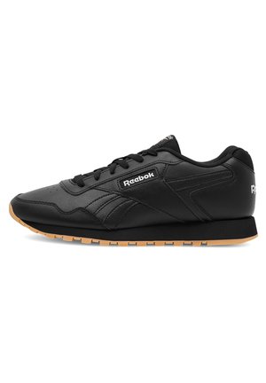 Schwarze Sneakers mit einem Obermaterial aus Leder, das eine strukturierte Oberfläche aufweist, mit Schnürsystem und einer Gummisohle. Mit Reebok-Logo an der Seite.