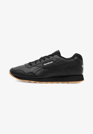 Zapatillas negras con parte superior de cuero, con un acabado texturizado, sistema de cordones y suela de goma. Incluye el logo de Reebok en el lateral.