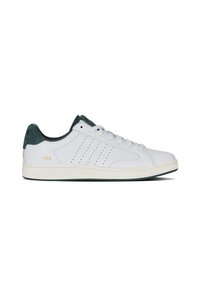 Adidași din piele albă cu accente din suede verde, design perforat și talpă din cauciuc off-white în contrast. Numele mărcii și anul sunt embosate pe călcâi.