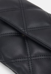 Černé kožené pouzdro s prošívaným vzorem, které má diagonální šití a hladkou strukturu. Překládané zapínání na klapku zajišťuje bezpečný přístup.