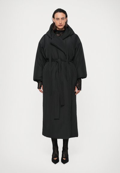 Cappotto oversize nero imbottito con cappuccio, vita con cintura e maniche lunghe. Presenta una texture liscia e una lunghezza fino al ginocchio.