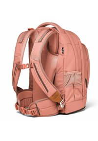 Rosa Stoff-Rucksack mit gepolsterten Mesh-Trägern, verstellbarem Brustgurt, Seitentasche und Lederakzent nahe der Basis.