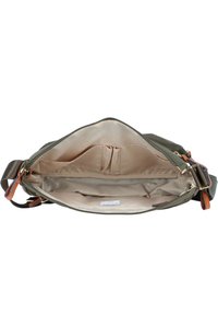 Interno della borsa in tessuto verde con rivestimento beige, dotato di due tasche laterali e progettazione pulita e ampia. Chiusura con zip e tracolla regolabile.