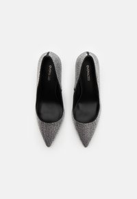 Sølv høye hæler med spiss tå, prydet med rhinestones, glatt svart innersåle og strømlinjeformet silhuett.