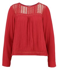 Rote Bluse mit langen Ärmeln aus strukturiertem Stoff, einer Spitzenblende mit geometrischen Mustern und einem gerafften Ausschnitt.