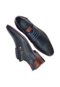 Donkerblauwe leren schoenen met een gestructureerde afwerking, voorzien van bruine accenten, blauwe veters en een ronde neus. Lichtpaarse zool benadrukt het ontwerp.