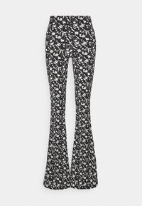 Uppblåsta byxor i en elastisk tyg, med en svart bakgrund och ett vitt blommönster genom hela plagget. Hög midja.