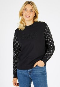 Sweatshirt noir avec devant texturé et détails de logo. Manches longues avec motif en losange et embellissements. Coupe décontractée avec encolure ronde.