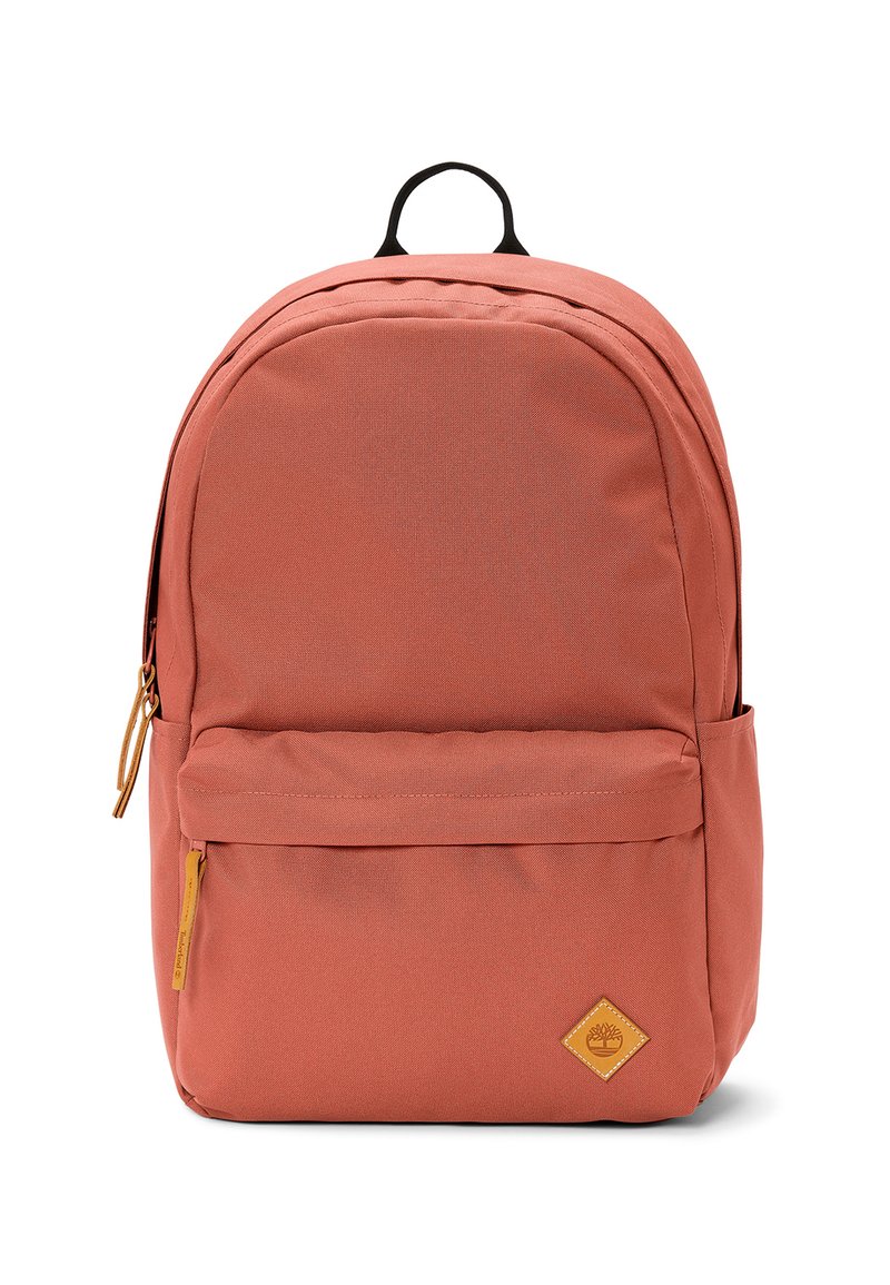 Mochila coral hecha de tela texturizada, con un bolsillo frontal con cremallera, acentos negros y un parche con forma de diamante.