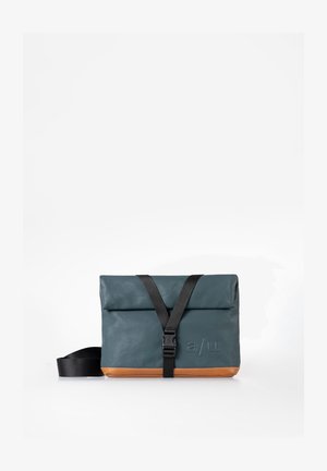 Kompakte Messenger-Tasche aus türkisem und braunem Leder mit schwarzem verstellbarem Riemen und vorderer Schnallenverschluss, geprägt mit dem "a/u"-Logo auf der Vorderseite.