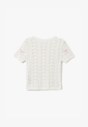 Suéter blanco de punto con mangas cortas, que presenta un patrón texturizado y un pequeño lazo rosa en la manga izquierda.