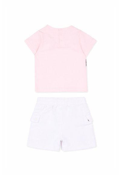 Haut rose clair à manches courtes avec des boutons au niveau de l'encolure, associé à un short blanc avec poches latérales et taille élastique.