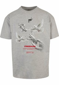 Graues Baumwoll-T-Shirt mit einem Grafikdesign von Tauben und Ketten, mit dem Wort "FREIHEIT" in Rot und einem Copyright-Symbol unter dem Design.