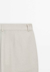 Jupe en lin beige clair avec ceinture et passants, vue de face depuis le haut sur fond blanc.