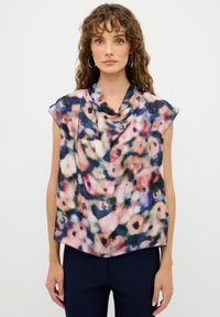 Blusa senza maniche in tessuto leggero e drappeggiato, caratterizzata da un motivo floreale nei toni del rosa, blu navy e verde, con scollatura a cappuccio e texture morbida.