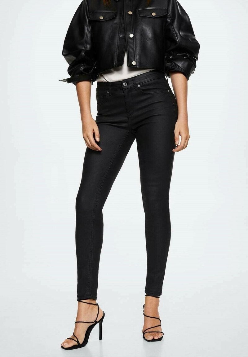 Zwarte skinny jeans van denim, met een hoge taille en een slanke pasvorm, gecombineerd met een kort zwart leren jasje en zwarte hakken met bandjes.
