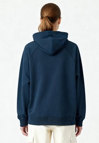 Sweat à capuche bleu marine avec cordon de serrage, poignets et ourlet côtelés ; mélange de coton doux, doté de manches raglan pour le confort et une liberté de mouvement optimale.
