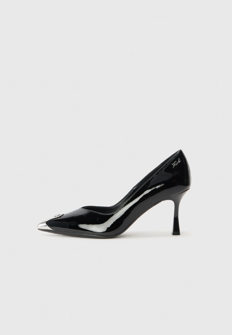 Svarte lakkpumps med spiss tå, sølvmetallisk hette og slank hæl. Har en jevn, blank finish og subtil logo-detalj.