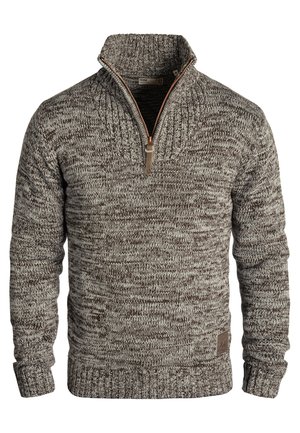 Pletený svetr s vysokým límcem a čtvrtzipem v kombinaci hnědých a šedých tónů, který má žebrovanou texturu a malou značenou etiketu.
