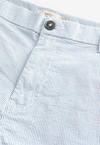 Pantalones cortos de tela a rayas azul claro y blanca con cierre de botón y un bolsillo frontal, fabricados con material transpirable.
