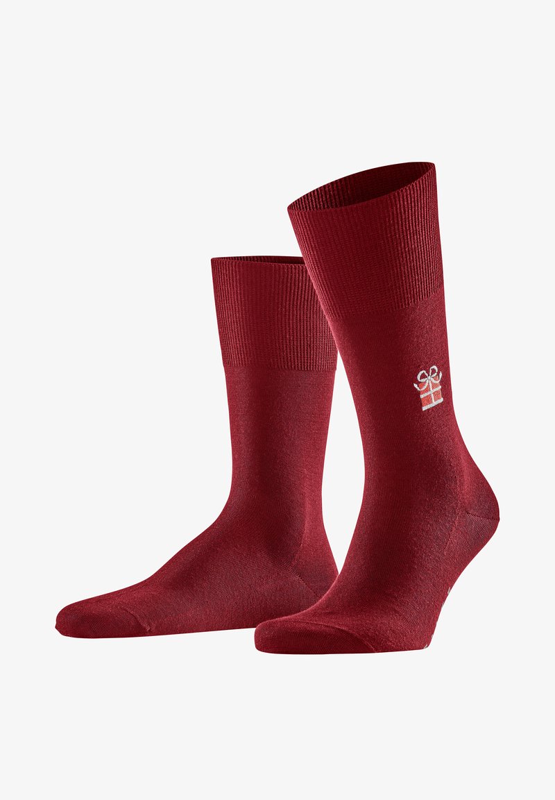 Chaussettes tricotées rouges avec un revers côtelé. Présente un logo subtil en forme de boîte-cadeau blanc sur le côté. Texture lisse, design mi-mollet.