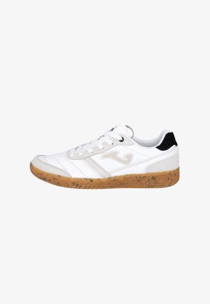 Zapatilla blanca de caña baja con detalles en beige y negro, suela de goma moteada, logo lateral y cordones blancos, mostrada desde el lado exterior.