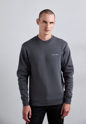 Grå sweatshirt lavet af bomuldsblanding, med rund halsudskæring, lange ærmer og et lille hvidt logo på brystet. Tekstureret stof.