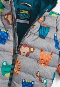 Quilted jacket featuring a gray fabric with colorful animal patterns, a teal interior, and a front zipper with a pull tab.