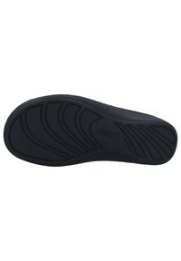 Black shoe sole with textured rubber, featuring zigzag patterns for grip, embossed brand name, and a smooth rounded edge.