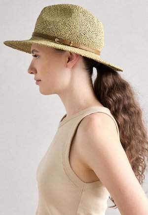 Chapeau en paille à large bord avec une bande en cuir marron clair et un détail de boucle, montré de côté contre un fond neutre.