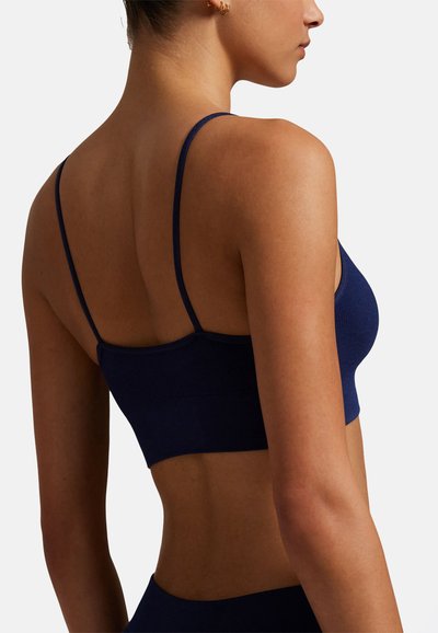 Námořnicky modrá žebrovaná bezešvá podprsenka s nastavitelnými tenkými ramínky, krátkým střihem a hladkou texturou s přiléhavým střihem.