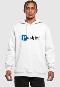 Hvid hættetrøje med en frontlomme, prydet med et blåt "P" logo og sort stiliseret tekst "Pushin'" med en spraymalereffekt.