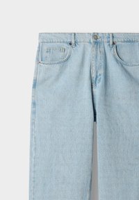 Lyse blå denimjeans med frontlommer, bælteløkker og en knaplukning i taljen, vist mot en ensfarvet bakgrunn.
