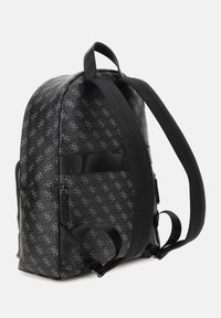 Mochila negra con un exterior estampado que presenta motivos de logotipo, dos correas para los hombros, un bolsillo lateral y una textura suave.