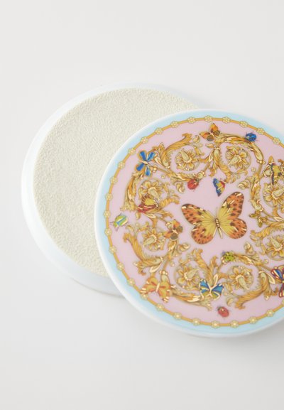 Okrogla kompaktna ličila z gladko rožnato površino, na kateri so zapletene zlate cvetlične in metuljaste podobe. Zadnja stran ima teksturirano, svetlo tonirano površino.