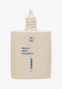 Flasche mit Foundation mit mattem Creme-Finish. Verfügt über eine spitze Kappe; beschriftet mit „Natural Sheer Foundation“ in blauer Schrift. Größe: 95 + 100.