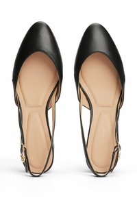 Chaussures en cuir noir à talon ouvert avec un bout pointu, des côtés découpés et une semelle intérieure beige. Caractéristiques de quincaillerie dorée sur la sangle ajustable.