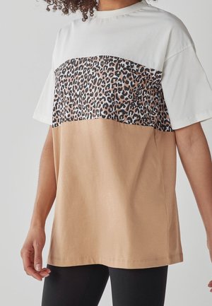 Camiseta a bloques de color con parte superior blanca, medio de leopardo y fondo beige. Hecha de algodón, con un ajuste relajado y mangas cortas.