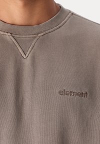 Grå sweatshirt med ribbad rund hals och V-söm detalj, har en liten broderad "element" logotyp på vänster bröstområde.