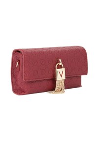 Pochette en cuir rouge texturé avec ferrures dorées, présentant un accent de cadenas et un détail de gland en chaîne. Forme arrondie avec fermeture à rabat.