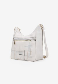 Bolso de mano de piel blanca con forma redondeada, que cuenta con un bolsillo frontal con cremallera. Decorado con coloridos patrones bordados. Correa de hombro ajustable.