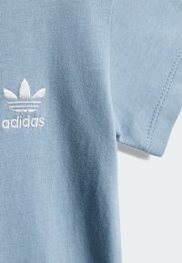 Svetlomodré bavlnené tričko s krátkymi rukávmi a rebrovanou textúrou. Obsahuje biele vyšívané logo a čisté švy.