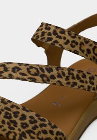 Σανδάλια με λεοπάρ μοτίβο και απαλή σουέντ υφή, με πολλαπλές λεπτές λουρίδες και καφέ μαξιλαρωμένη εσωτερική σόλα.