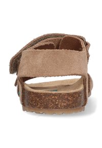 Sandal in camoscio marrone con una suola intermedia in sughero, design con cinturino regolabile e suola testurizzata, che mostra un'estetica minimalista.