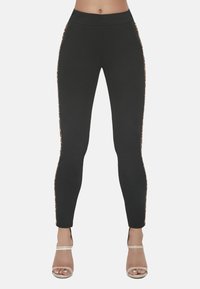 Czarne legginsy z wysokim stanem, z akcentami w panterkę wzdłuż bocznych szwów, wykonane z elastycznego materiału.