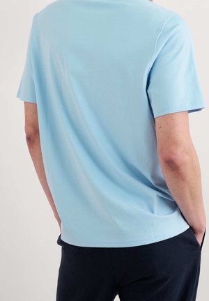 Jasnoniebieska bawełniana koszulka z okrągłym dekoltem i krótkimi rękawami. Projekt jest prosty, bez widocznych zdobień.