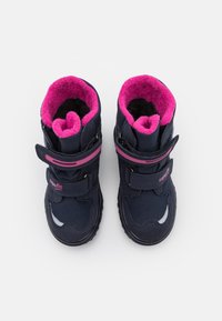 Tamsiai mėlynos vaikų botai su rožine vilnos pamušalu, Velcro diržais, tvirtu padu ir atspindinčiais akcentais matomumui.
